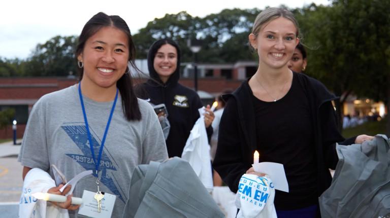 三个新来的大学生拿着蜡烛和东北风的t恤在第一夜